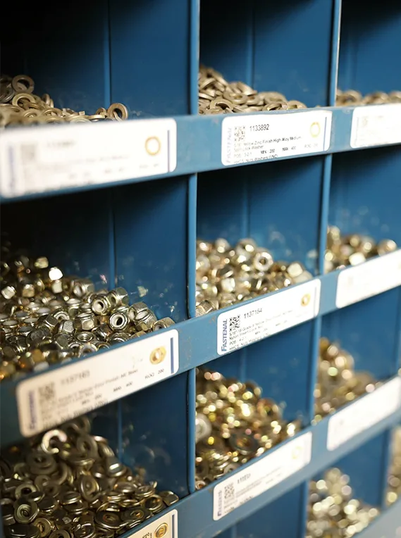 gold parts in each bin within a large blue shelf