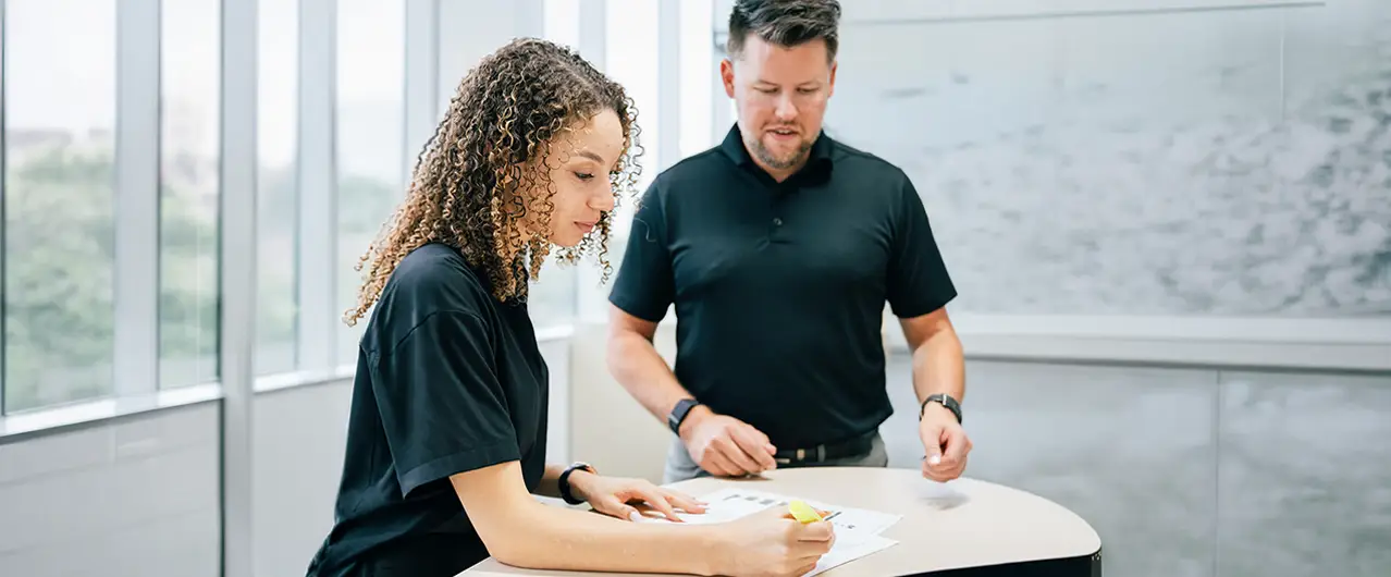 woman and man filling out leasing forms at a stand up table