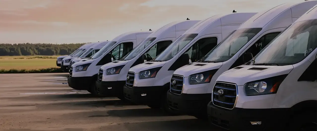 a row of fleet vans in white during a sunset