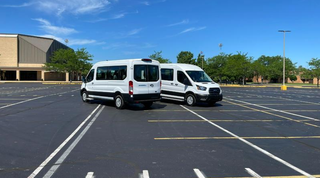 Two white electric vans parked in a parking lot.