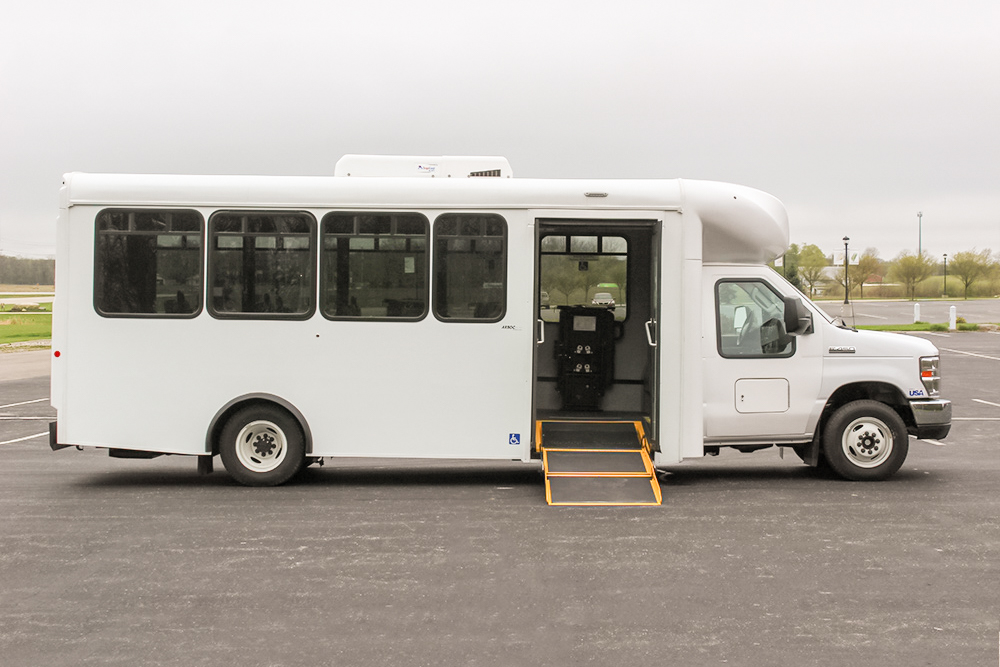 A white ARBOC Spirit of Freedom bus parked in a parking lot.