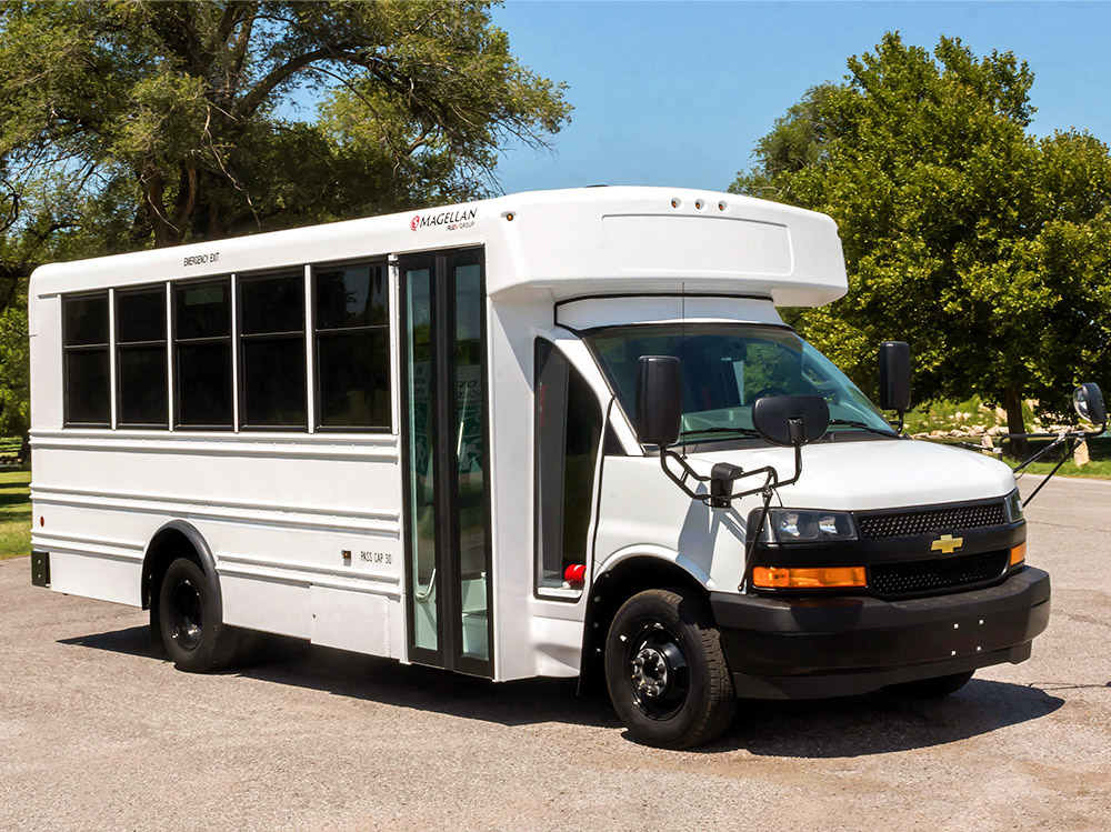 A white Activity MFSAV bus parked in a parking lot.