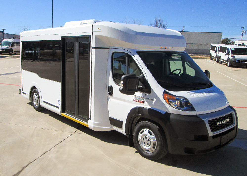 A white frontrunner passenger bus parked in a parking lot.