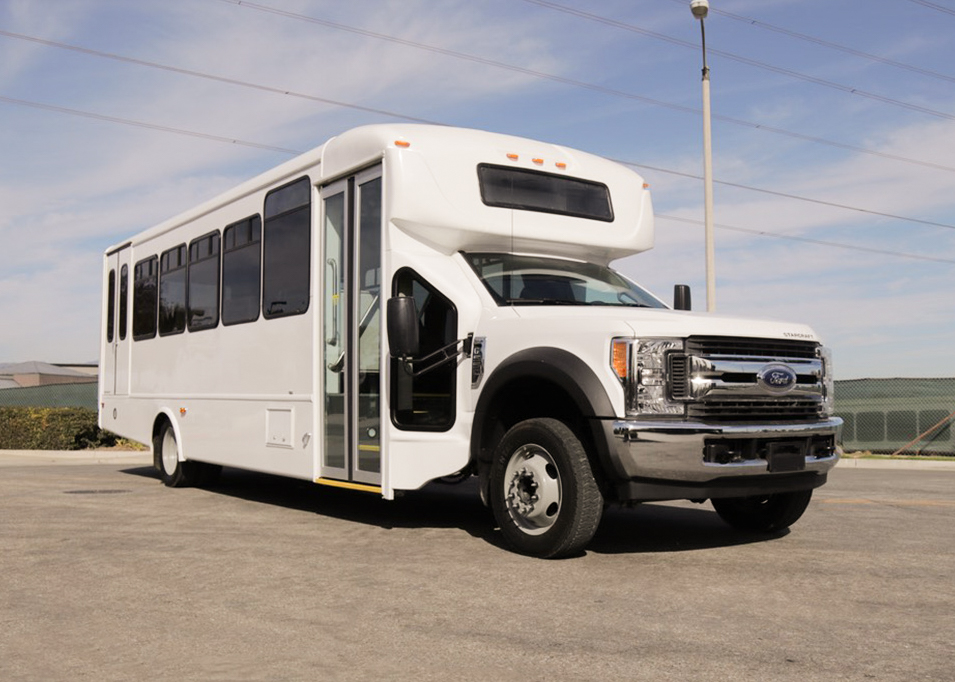 An alternative fuel CNG white bus parked in a parking lot.