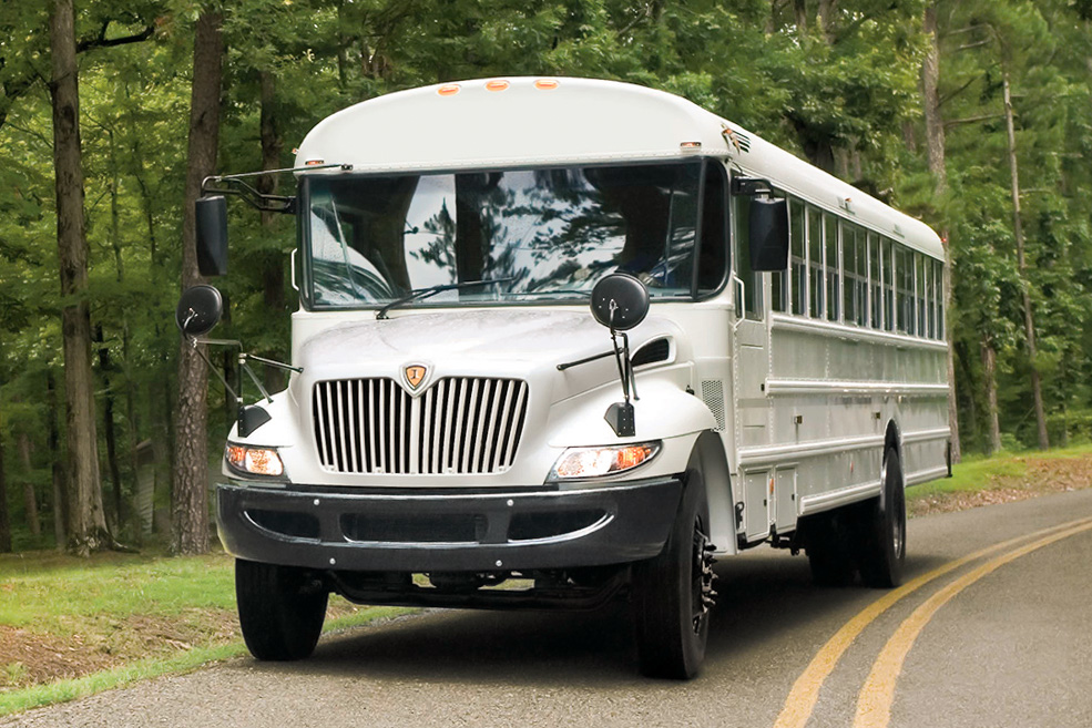 A white IC Corporation Type C MFSAB school bus driving down a country road.