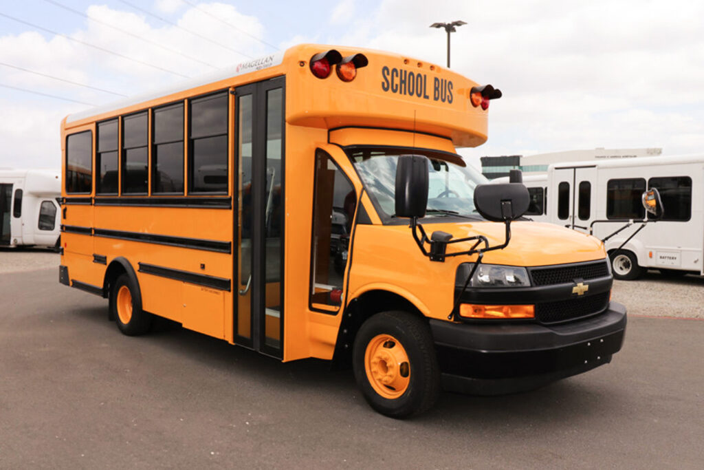 A yellow Magellan Type A school bus parked in a parking lot.