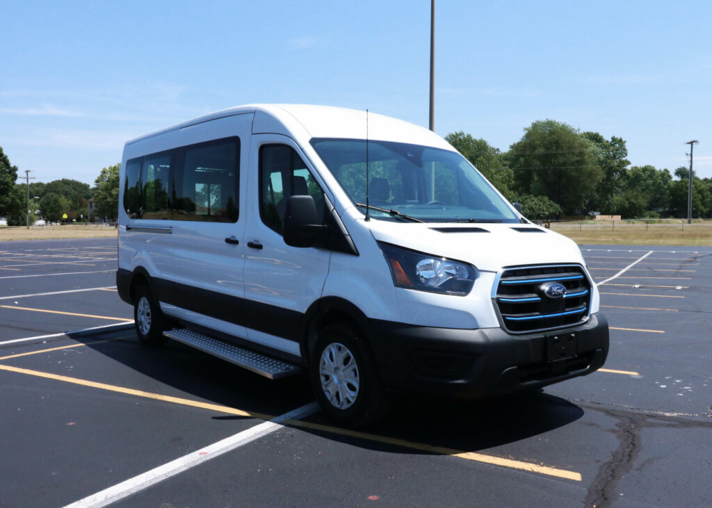 A white Ford E-Transit van parked in a parking lot.
