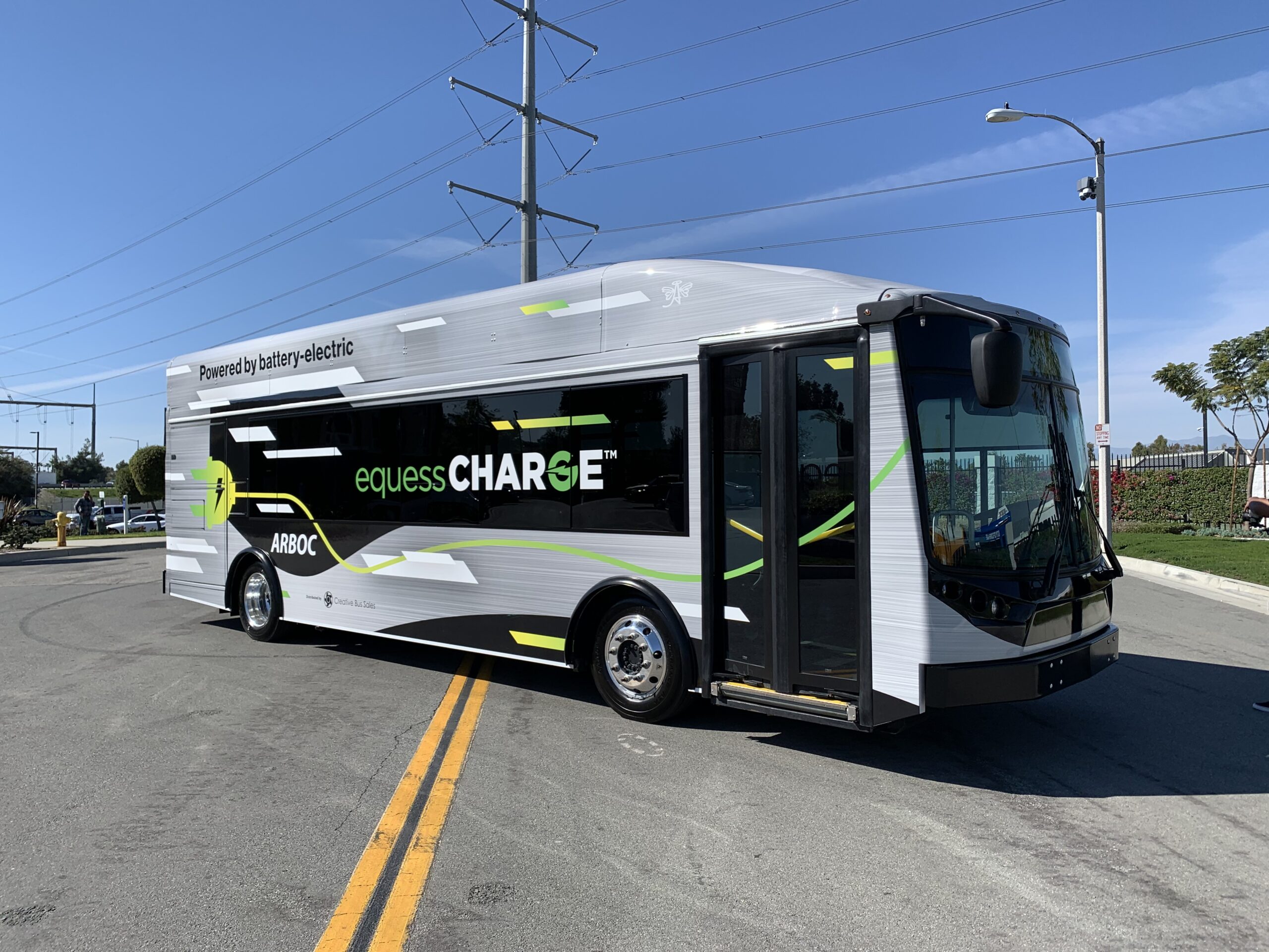 An electric bus, the 2021 ARBOC Equess CHARGE, is parked on the side of the road.