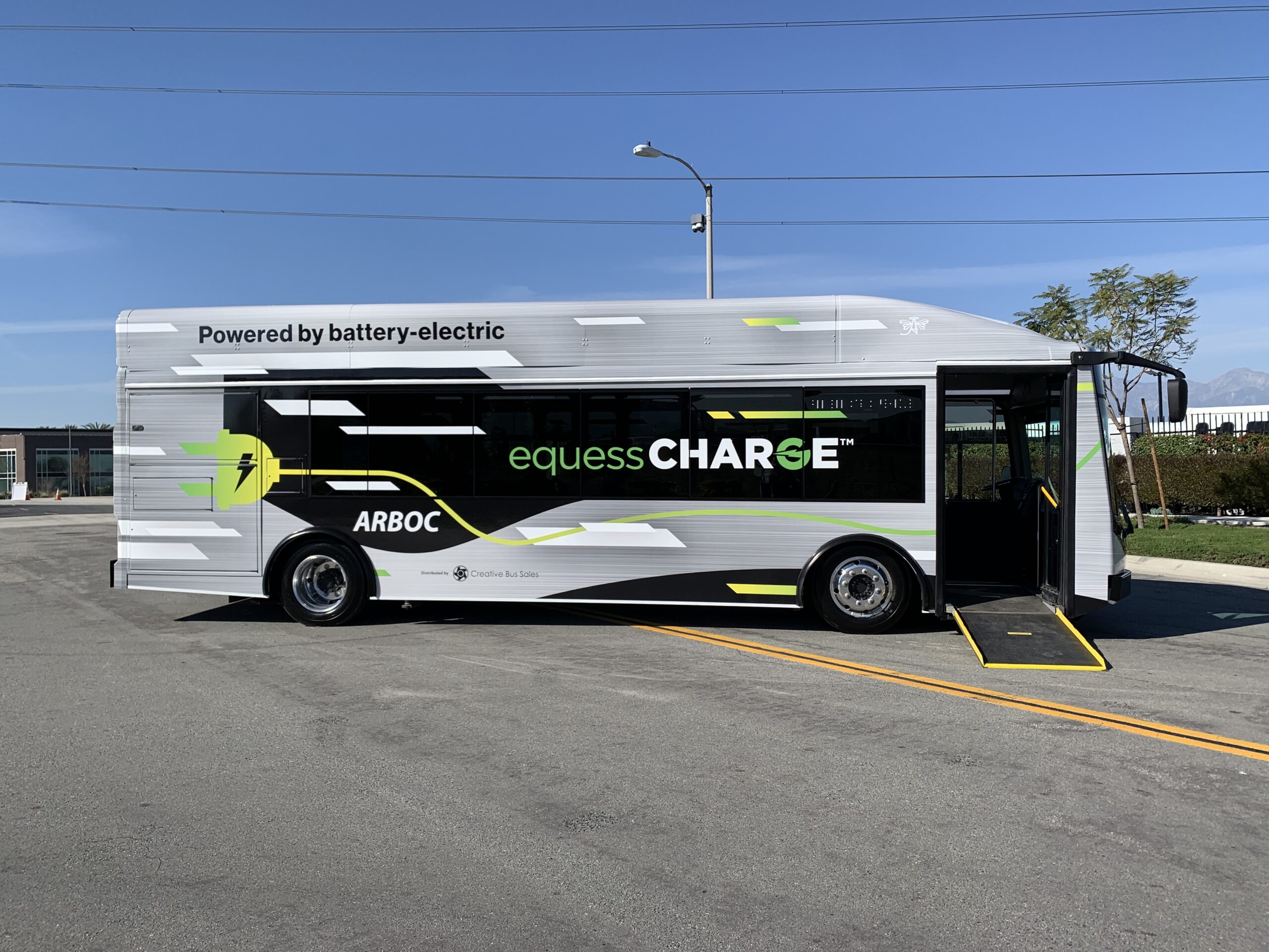 A 2021 black and white electric bus parked in a parking lot.