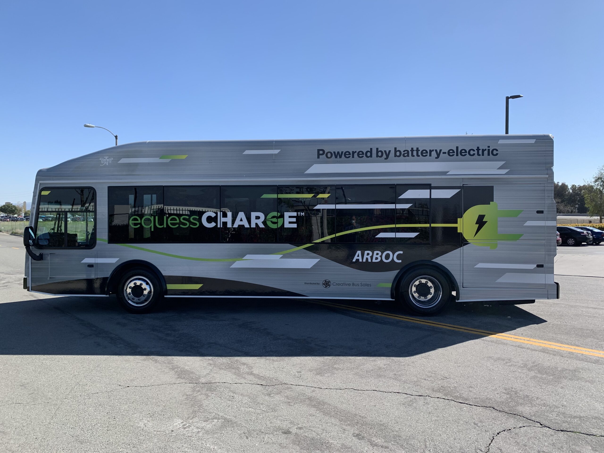 A 2021 ARBOC Equess CHARGE bus is parked in a parking lot.