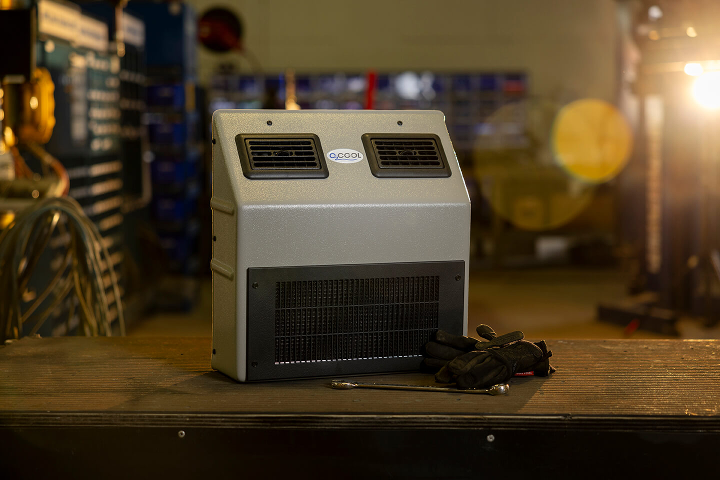 A portable air conditioner sits on a table in a workshop.