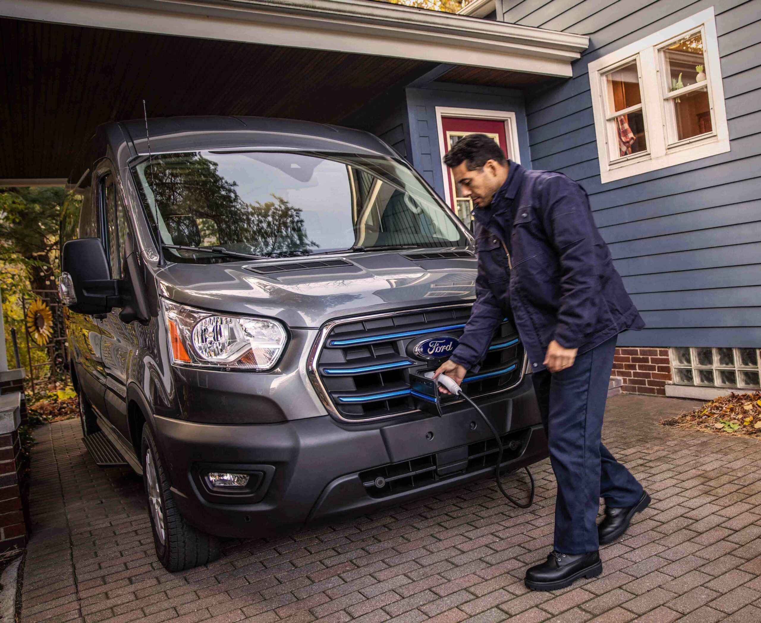A man installing an alternative fuel program for a Ford Transit van at a charging station.