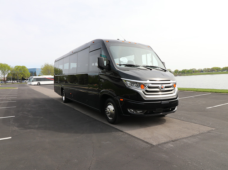 A black Marcopolo Grand bus parked in a parking lot.