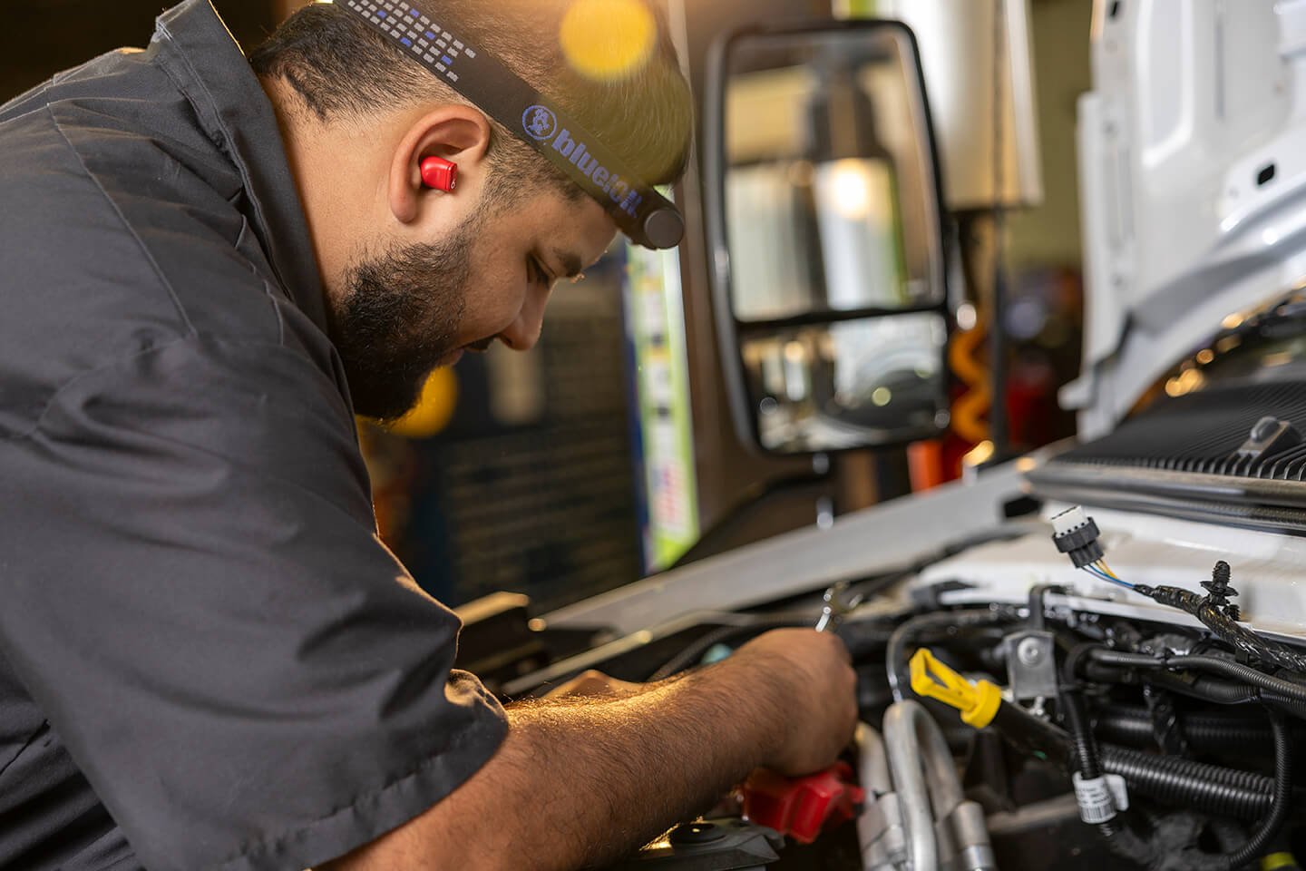 A mechanic working on the engine of a truck.