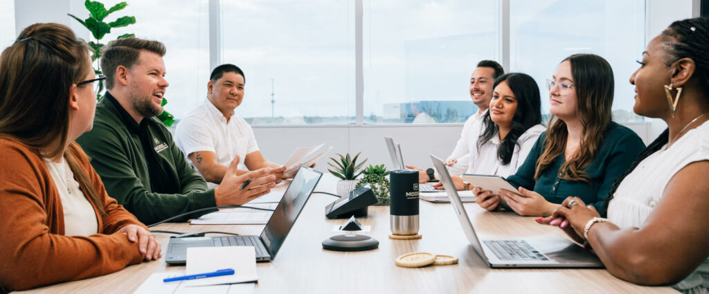 A group of people discussing and brainstorming ideas around a conference table.