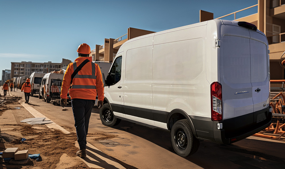 A contractor walking next to a Ford E-transit
