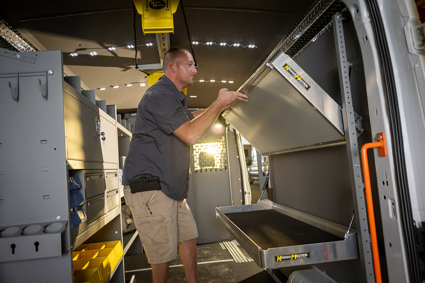 A man is installing shelving in a cargo van.
