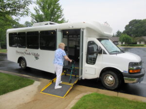 Low-floor shuttle bus by ARBOC picking up a senior passenger