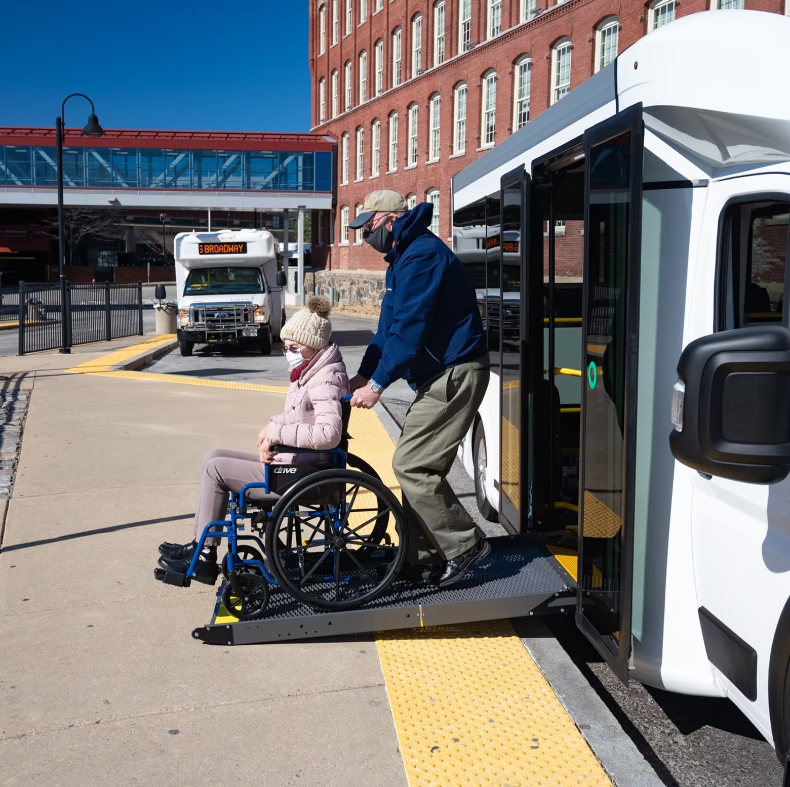 Person exiting an ADA vehicle from extended ramp of a wheelchair transportation vehicle.