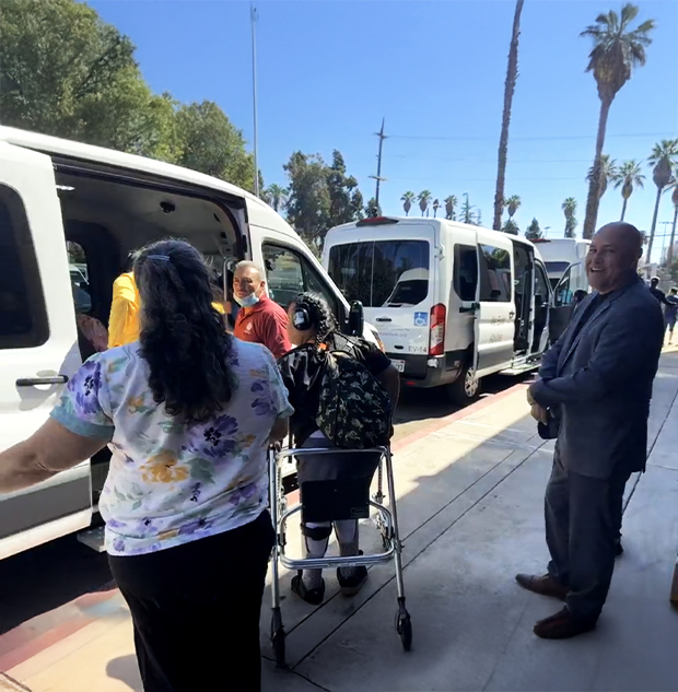 Community members enter an electric vehicle.