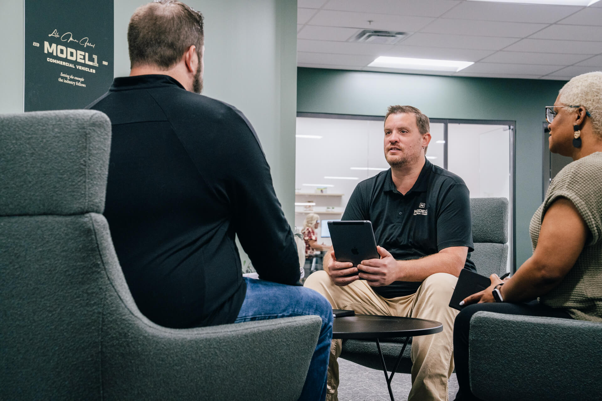 Three people having a meeting at Model 1 headquarters.