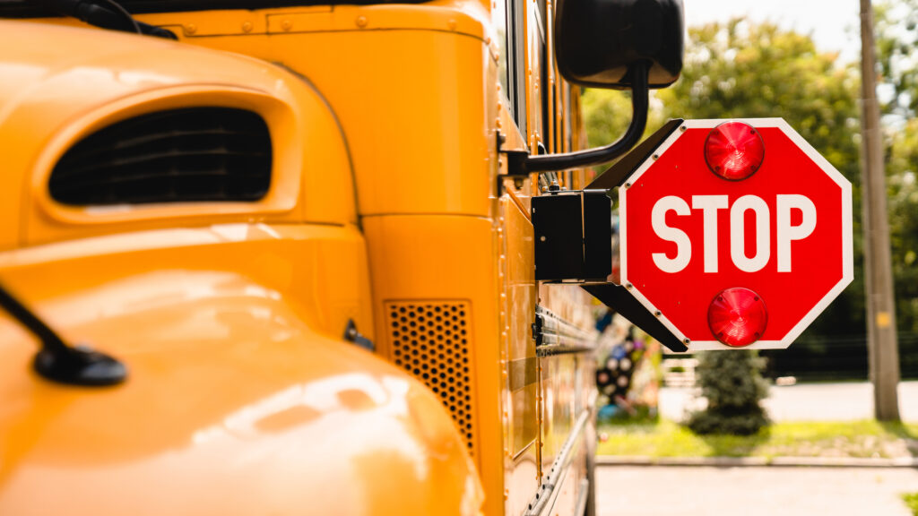 Close-up of a school bus stop sign, part of daily school transportation safety equipment